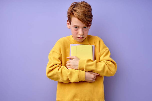 Wonk school boy holding stack of books, pressed to chest. portrait, copy space - Foto, Imagem