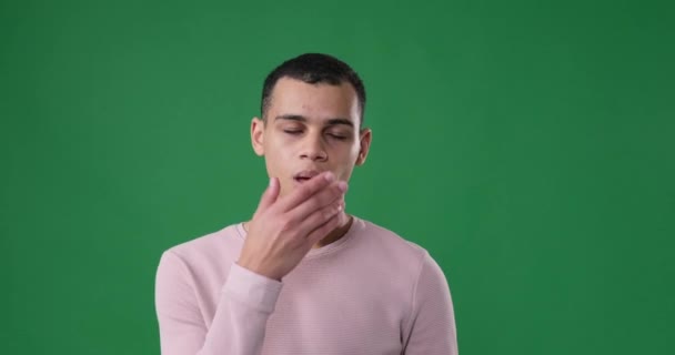 Schläfriger Mann gähnt vor grünem Hintergrund - Filmmaterial, Video
