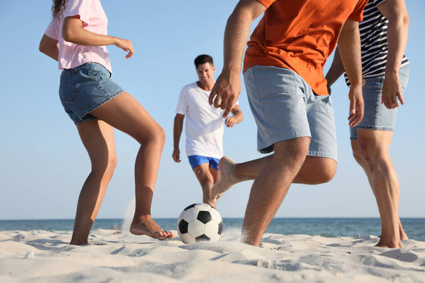 Group of friends playing football on beach, closeup - Fotoğraf, Görsel