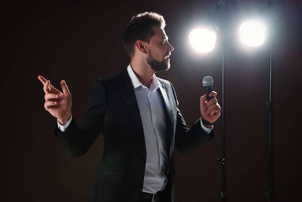 Motivational speaker with microphone performing on stage - Fotoğraf, Görsel
