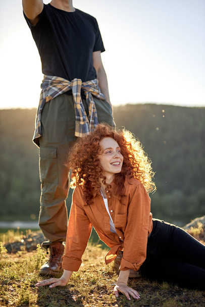 Romantic couple of young people relaxing on head of mountains, posing at sunshine - Photo, image