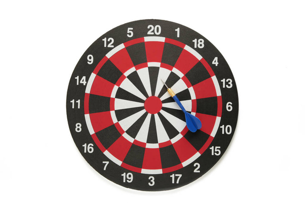 Dart board with blue dart isolated on white background. Top view. - Fotografie, Obrázek