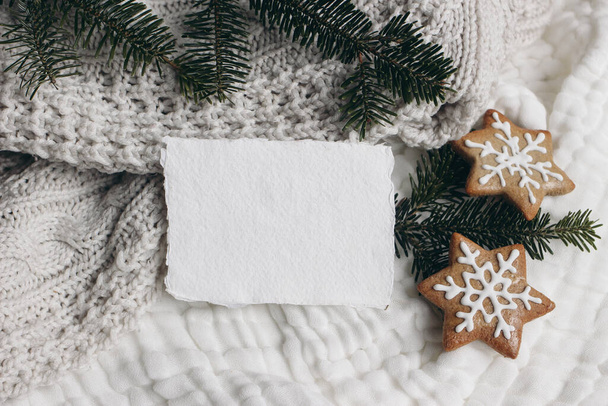 Christmas composition. Blank cotton card mockup, star shaped gingerbread cookies and fir tree branches. White muslin cotton table cloth, throw. Flatlay, top view. Winter holiday lifestyle concept. - Fotó, kép