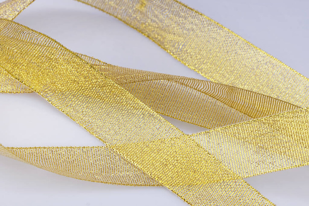 Background with golden packaging decorative ribbons isolated on white - Foto, afbeelding