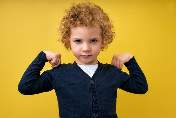 Look at my muscle, Im strong. Portrait of adorable little boy in T-shirt feeling powerful - Zdjęcie, obraz