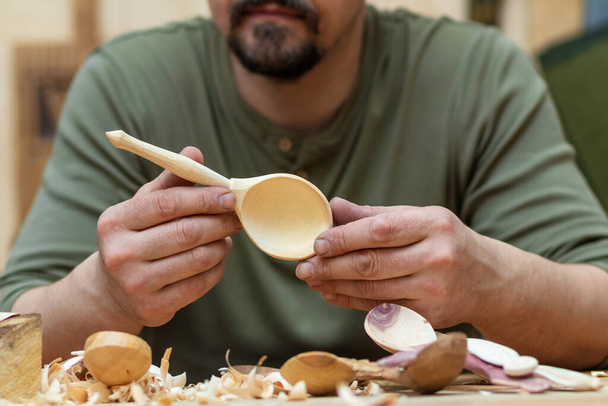 Майстер ложки у своїй майстерні з дерев'яними виробами та інструментами
 - Фото, зображення