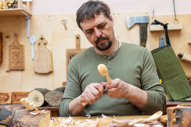Ambacht maakt houten lepels en andere artikelen in zijn atelier - Foto, afbeelding