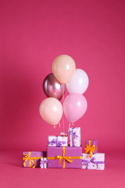 Molte scatole regalo e palloncini vicino sfondo rosa brillante - Foto, immagini