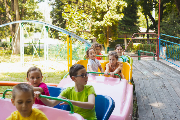 The happy little children are resting in the amusement park - Foto, imagen