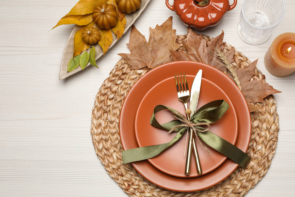 Beautiful place setting with autumn decor on white wooden table, flat lay - Fotó, kép