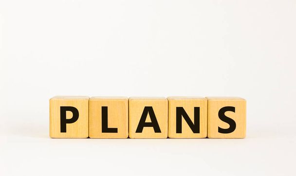 Plans symbol. The concept word 'plans' on wooden cubes on a beautiful white table. White background. Business and plan or plans concept. - Zdjęcie, obraz