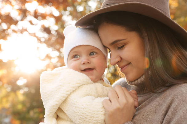 Happy mother with her baby daughter outdoors on autumn day - Foto, afbeelding