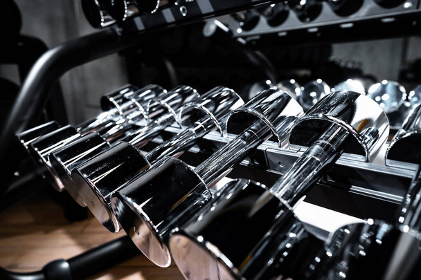 Rows of metal dumbbells on rack for bodybuilding in gym - Foto, Imagen