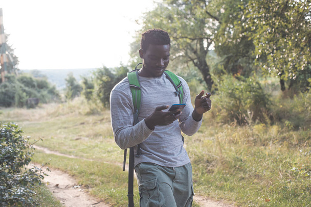 The beautiful young man with a backpack is hiking in the forest - Fotó, kép