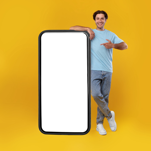 Man pointing at big white empty smartphone screen, mockup - Foto, afbeelding