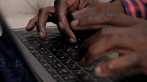 Fechar o homem afro-americano mãos digitando texto no laptop teclado em casa - Filmagem, Vídeo