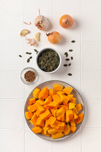 Ingredients for pumpkin puree soup on white plate in kitchen - Foto, Imagen