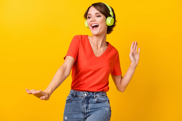 Photo of nice brunette optimistic lady dance listen music wear red t-shirt isolated on vivid yellow color background - Фото, зображення