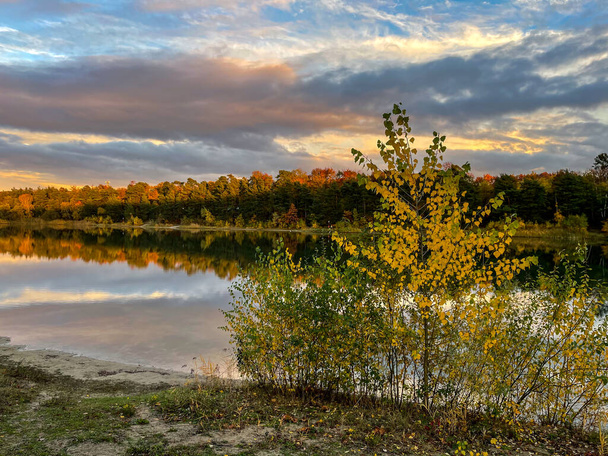 Um lago pequeno bonito em Hesse, Alemanha em um dia ensolarado no outono com uma floresta colorida que reflete na água. - Foto, Imagem