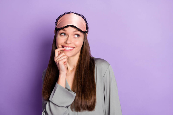 Portrait of attractive trendy bewildered cheerful girl wearing pajama thinking copy space isolated over violet purple color background - Foto, afbeelding