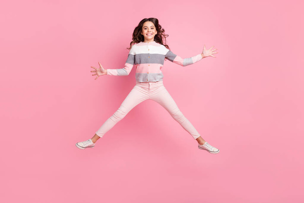 Полное фото тела активной счастливой очаровательной девушки подпрыгивает воздух хорошего настроения выходные изолированные на розовом цвете фоне - Фото, изображение