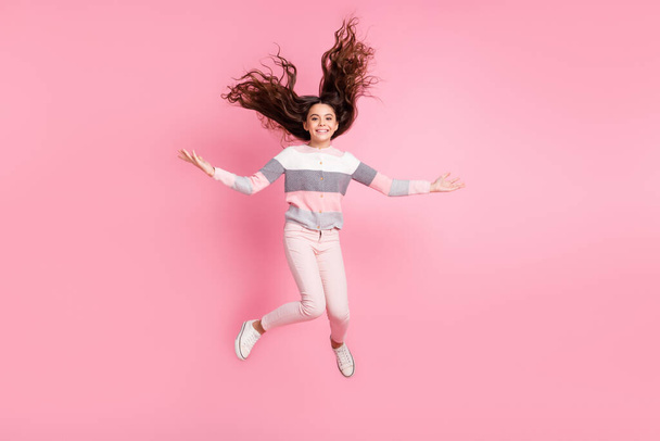 Full length photo of funky funny little girl jump up air hair fly enjoy vacation isolated on pink color background - Foto, afbeelding