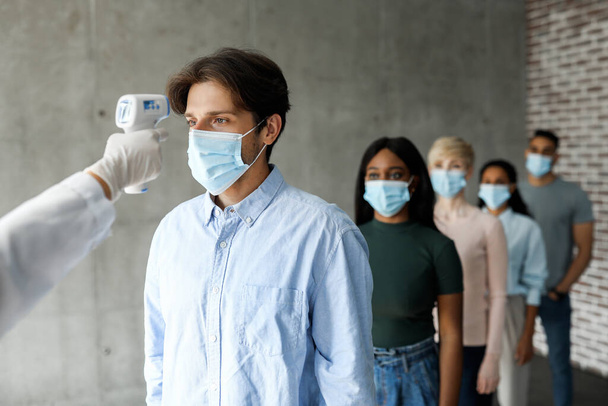 医療用マスクの患者の国際グループ体温をチェック - 写真・画像