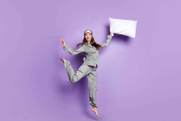 Full length body size view of nice trendy glad cheerful carefree girl holding pillow jumping having fun isolated on violet purple color background - Photo, Image