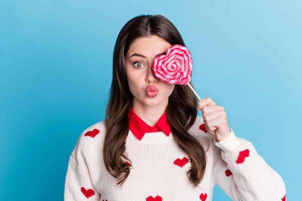 Photo of funny flirty young lady wear hearts print sweater cover eye candy lips pouted isolated blue color background - Fotó, kép