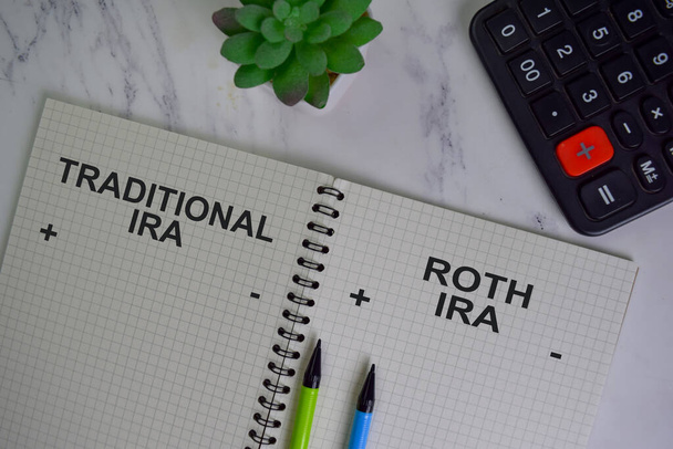 Traditional IRA and Roth IRA write on a book isolated on Wooden Table. - Photo, Image