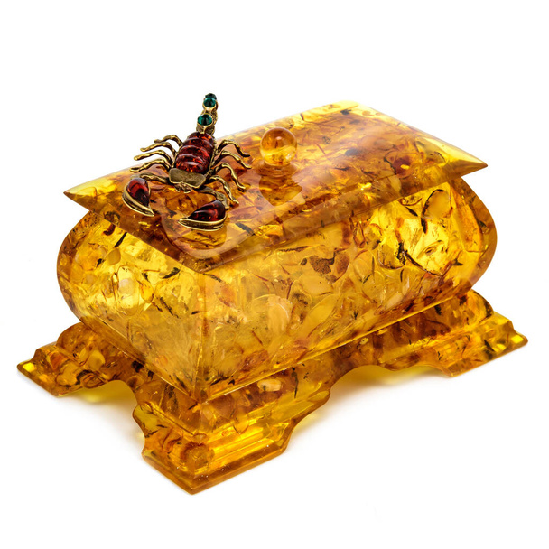 Bronzový škorpión na jantarové šperkovnici pro ukládání drobných předmětů a doplňků, interiérová výzdoba. Žlutá oranžová rakev z přírodní pryskyřice na bílém pozadí. - Fotografie, Obrázek