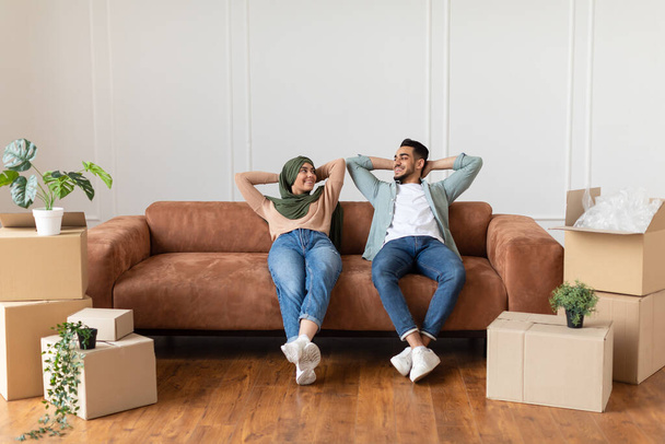 Family relaxing on couch after moving in new home - Photo, Image
