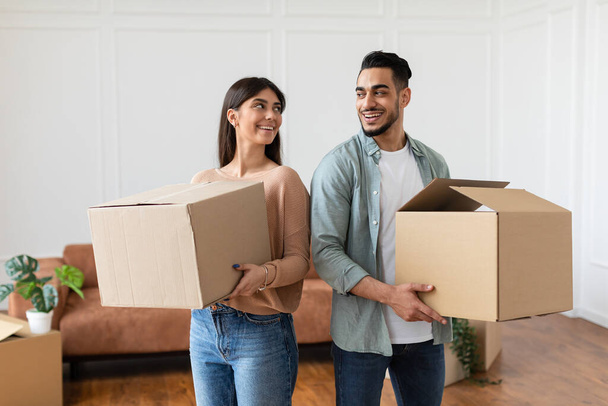 Happy millennial couple holding cardboard boxes, relocation concept - Photo, Image