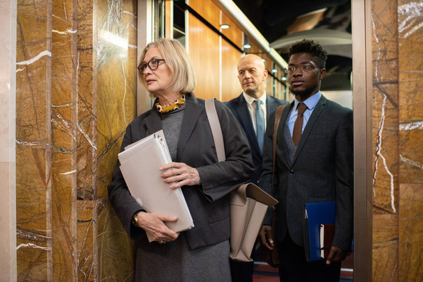 Группа современных межкультурных сотрудников с документами в ожидании лифта - Фото, изображение