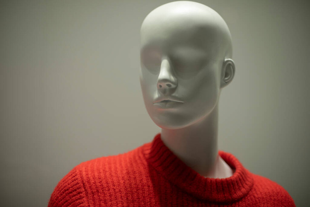 Mannequin in a red sweater. Shop window. Wool-bound clothing. Women's mannequin without hair. - 写真・画像
