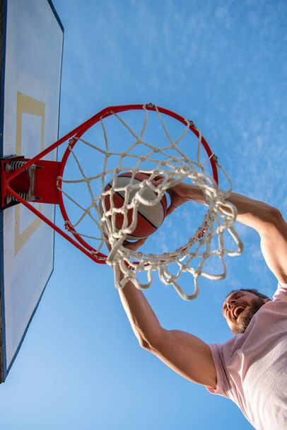 hombre exitoso con pelota de baloncesto en la cancha. jugador de baloncesto profesional entrenamiento al aire libre. - Foto, Imagen