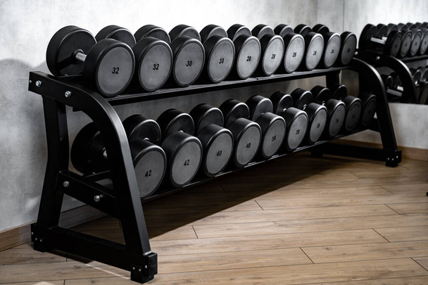 Rows of metal dumbbells on rack for bodybuilding in gym - Foto, imagen