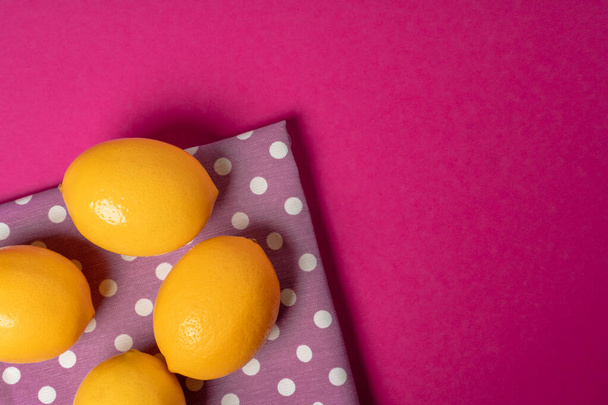 Ripe lemons on bright pink paper background - Foto, Imagem