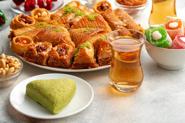 Various Turkish sweets and cup of tea on white textured background - Φωτογραφία, εικόνα