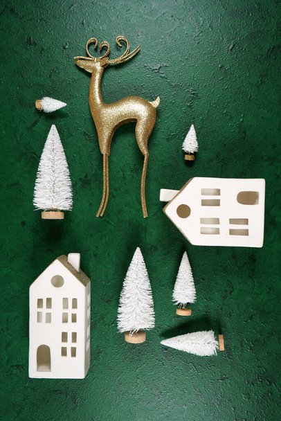 Decorazioni natalizie sfondo in stile con renne d'oro e case di villaggio. - Foto, immagini