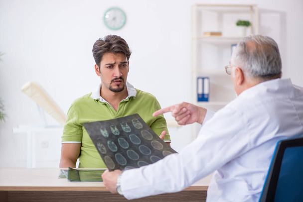 Paciente masculino joven que visita al radiólogo médico anciano - Foto, imagen