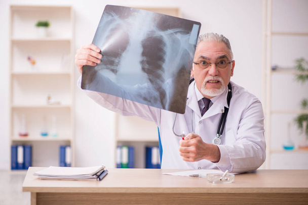 Stary lekarz radiolog pracujący w klinice podczas pandemi - Zdjęcie, obraz