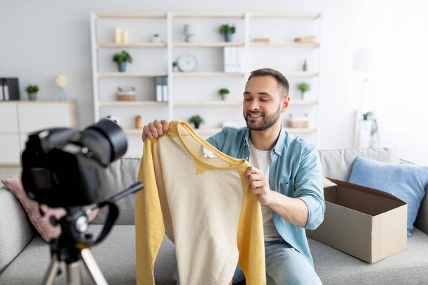 Blogueiro de moda gravação de conteúdo de vídeo, unboxing novo suéter em casa - Foto, Imagem