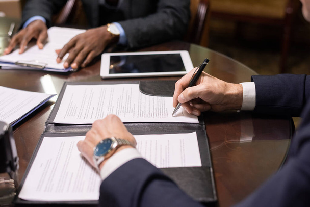 Yetişkin bir avukatın kontrat ya da başka bir belgeyi imzalaması - Fotoğraf, Görsel
