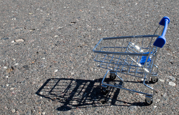 Empty grocery cart in an empty parking lot near a supermarket. - Zdjęcie, obraz