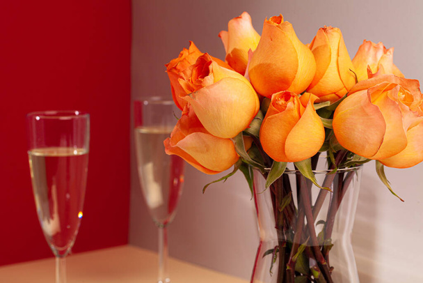 photo of champagne glasses with roses in a vase close up - Foto, Bild