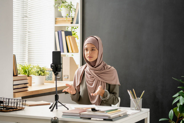 Fiatal magabiztos nő hidzsáb nézi okostelefon kamera - Fotó, kép