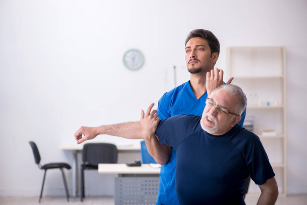 Old man visiting young male doctor - 写真・画像