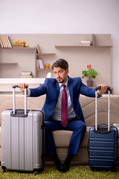 Young businessman preparing for trip at home - Foto, imagen