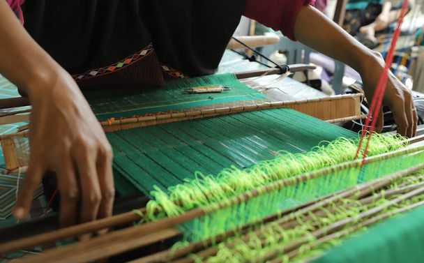close up de mãos fazendo trabalho de tecelagem usando ferramentas tradicionais - Foto, Imagem